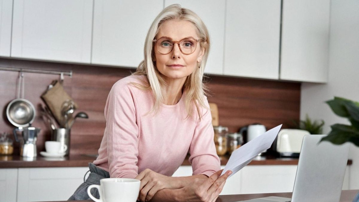 Woman reviewing life insurance documents at her kitchen table in Dubai