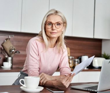 Woman reviewing life insurance documents at her kitchen table in Dubai